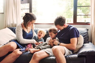 Parents and kids sitting on sofa at home