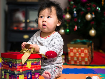 Cute baby girl with christmas gift at home