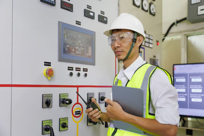 Engineer working on the checking status switchgear electrical energy distribution substation. 