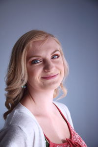 Portrait of smiling woman against wall