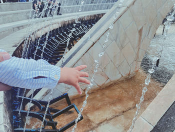 High angle view of little hand playing with water