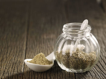 Close-up of cumin seeds in glass jar on table