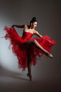 Full length of woman dancing against white background