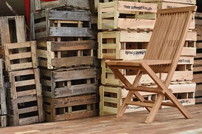 Stack of wooden crate and empty chair in warehouse