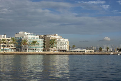 Buildings in city against cloudy sky