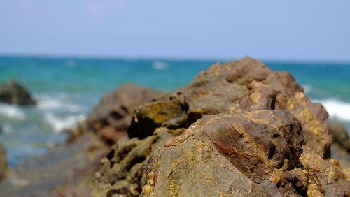 Close-up of rocks on beach against sky