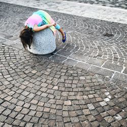 Rear view of boy on cobblestone