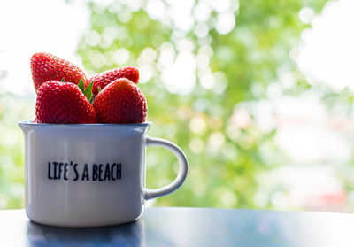 Close-up of strawberries in cup on table