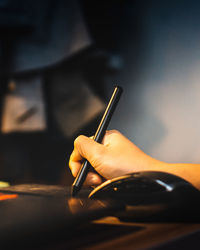 Cropped hand using graphics tablet on table