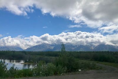 Scenic view of lake by mountains against sky