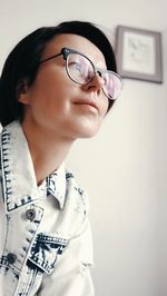 Close-up of mature woman looking away sitting at home