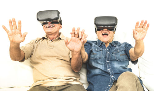 Happy friends wearing virtual reality simulator at home