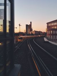 Railroad tracks in city against sky