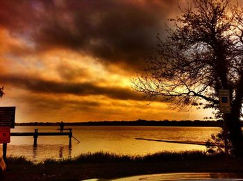 Scenic view of sea against cloudy sky at sunset