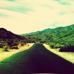 Empty road leading towards mountains