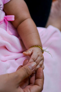 Cropped hand of mother holding baby hand