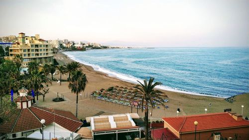 High angle view of houses by sea against sky