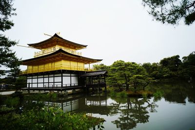 Building by lake against sky