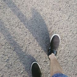 Low section of man standing on road