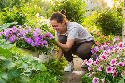 Side view of young woman picking plants