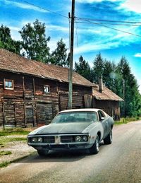 Cars on road against cloudy sky