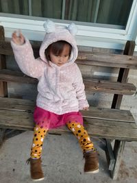 Full length of cute baby girl sitting on wood