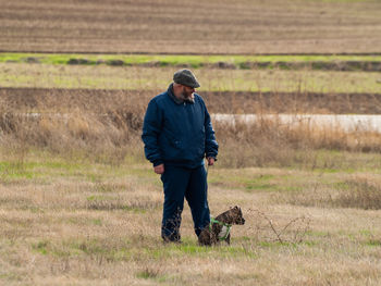 Man with dog standing on grass