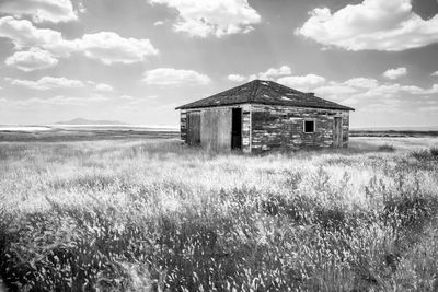 Abandoned house on field against sky