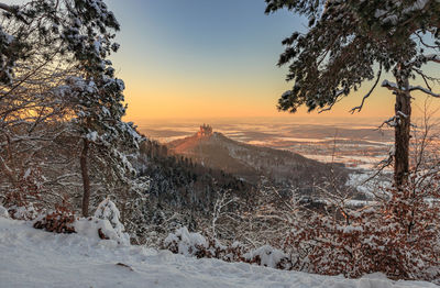 Scenic view of snow covered land during sunset