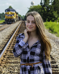 Portrait of beautiful young woman on railroad track