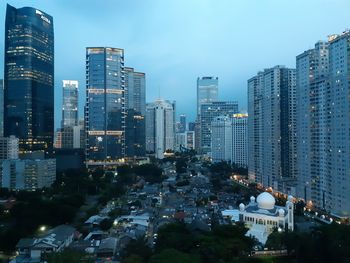 Illuminated buildings in city against sky