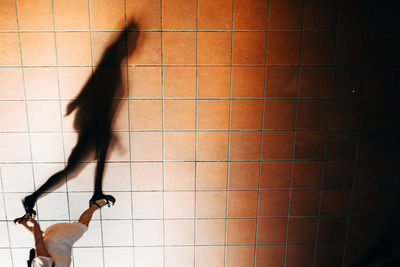 Low section of woman walking with shadow on footpath