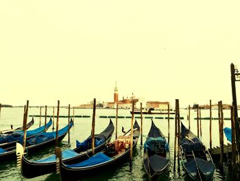 Boats moored in canal against clear sky