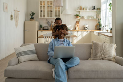 Woman sitting in living room at home