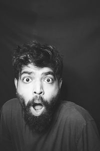 Portrait of young man against black background