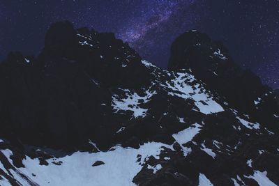 Scenic view of snowcapped mountains against sky at night