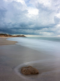 Scenic view of rocks on beach against sky