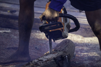 Low section of lumberjack cutting wood