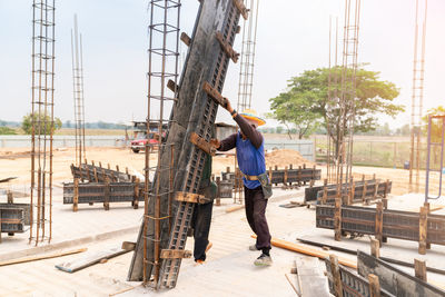 Worker is installing and assembling column formworks for concrete filling at building site..