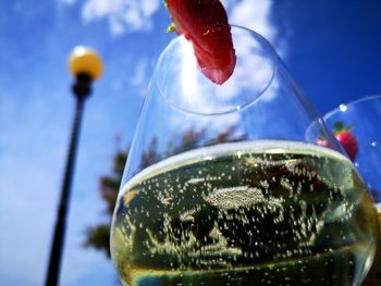 Close-up of drink in glass against sky