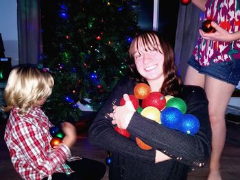 Portrait of teenage girl with christmas baubles at home