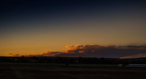 Scenic view of silhouette field against sky during sunset