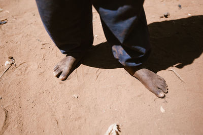 Low section of man with shadow on sand