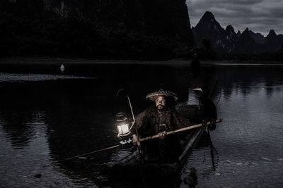Portrait of man on boat in water at night