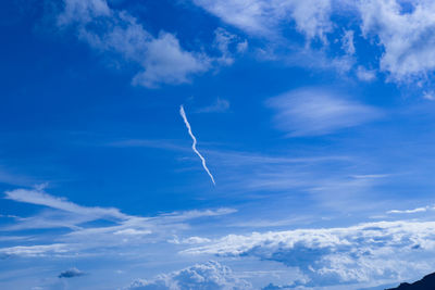 Low angle view of vapor trail against blue sky