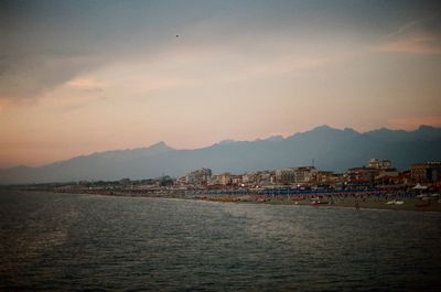 View of city at waterfront during sunset