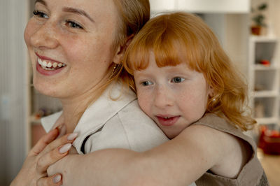 Happy daughter hugging mother at home