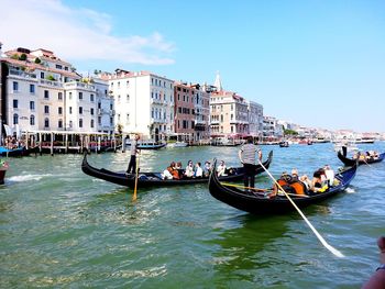 People on boat in canal by city