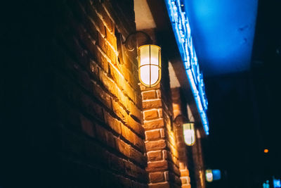 Low angle view of illuminated light bulbs at night