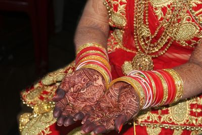 Midsection of bride showing henna tattoo